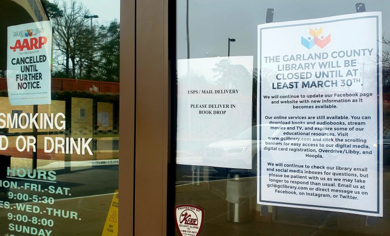 A sign on the Garland County Library door on Monday notifies patrons it is closed at least until March 30 due to the coronavirus pandemic. - Photo by Grace Brown of The Sentinel-Record