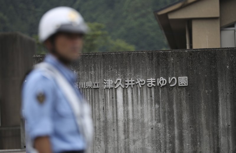 FILE - In this July 26, 2016, file photo, a police officer stands guard at the gate of Yamayuri-en, a facility for the handicapped where a former care home employee killed disabled people, in Sagamihara, outside Tokyo. The Yokohama District Court sentenced Satoshi Uematsu, 30, to death Monday, March 16, 2020, for killing 19 disabled people and injuring 24 others four years ago in the deadliest mass attack in postwar Japan. (AP Photo/Eugene Hoshiko, File) story.lead_photo.caption