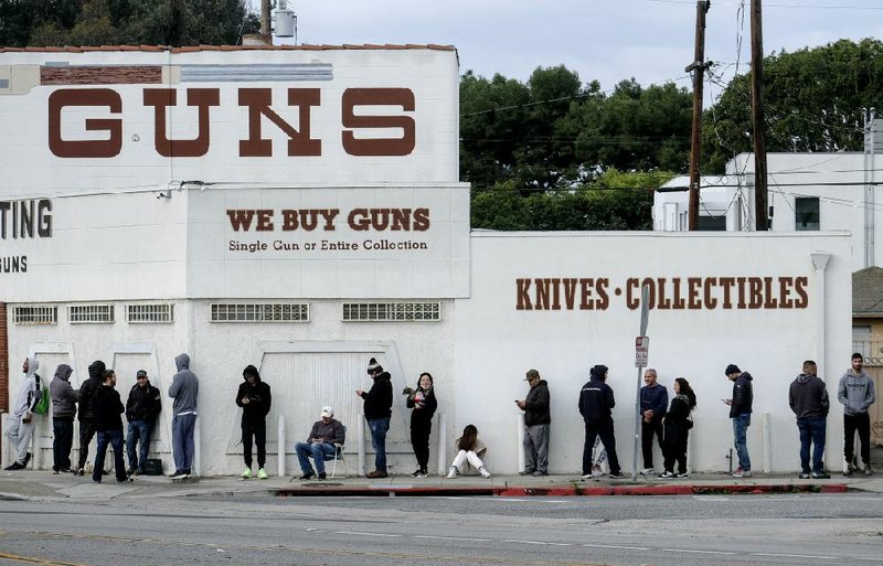 People wait in line Sunday to enter a gun store in Culver City, Calif. The coronavirus pandemic has fueled a spike in rearms sales. (AP/Ringo H.W. Chiu) 