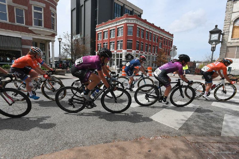 In this file photo, professional women cyclists race through downtown Fayetteville on April 7, 2019 during the Joe Martin Stage Race. (NWA Democrat-Gazette/J.T. Wampler)
