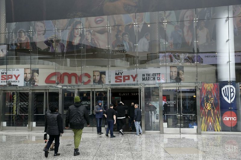 People enter an AMC theater on Saturday in Los Angeles. Limited access to theaters because of the coronavirus pandemic should mean a spike in online video streaming services, analysts say. (AP/Marcio Jose Sanchez) 
