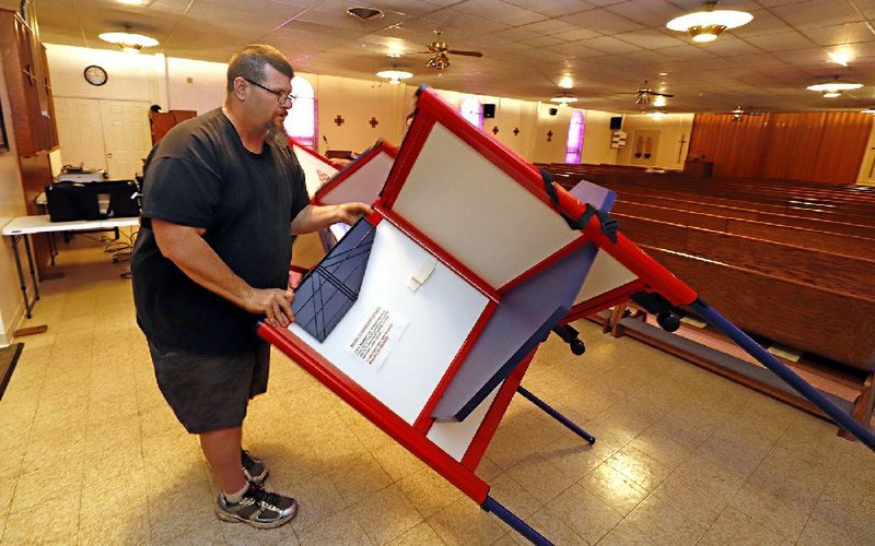 Patrick Lathem packs up voting equipment Tuesday at a polling place in Our Lady of Lourdes church in Wintersville, Ohio, after Gov. Mike DeWine declared a health emergency to halt the state’s primary election. More photos at arkansasonline.com/318elections/.
(AP/Gene J. Puskar)