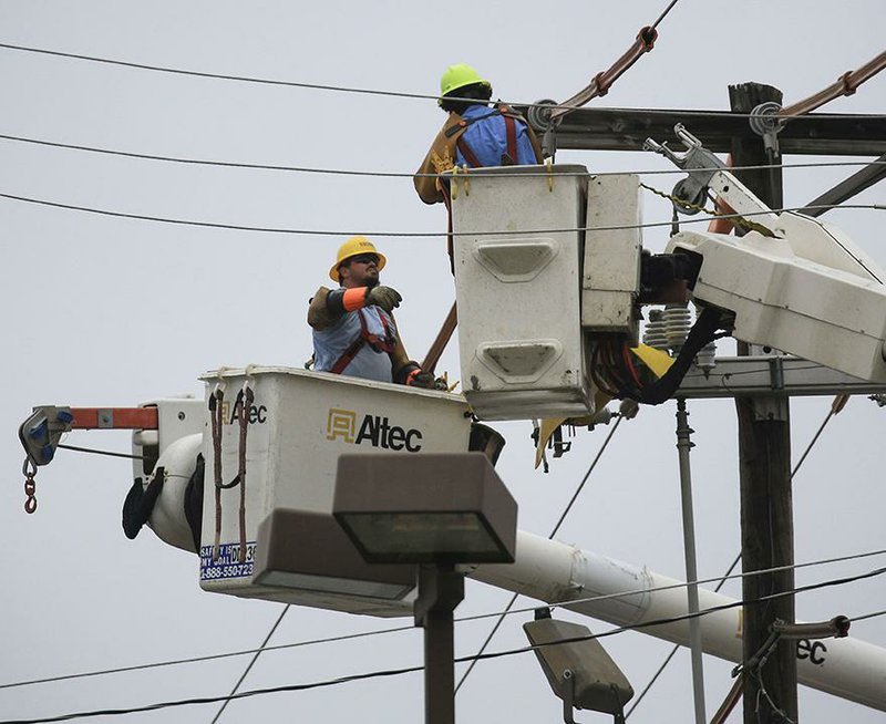 Linemen for a utility contractor work Tuesday, March 17, 2020, in Sherwood changing a utility pole on East Kiehl Avenue near Arkansas 107. Utility companies across Arkansas have pledged not to disconnect customers during the coronavirus pandemic.