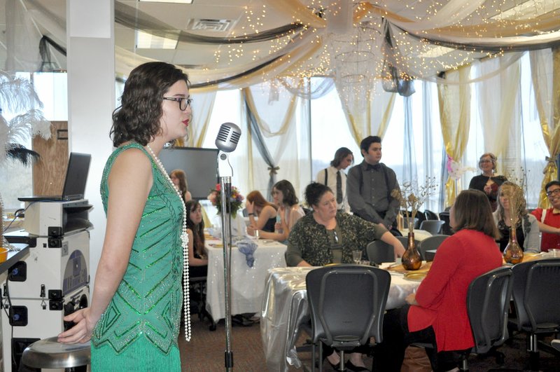 RACHEL DICKERSON/MCDONALD COUNTY PRESS Elena Josephine, dressed in a 1920s-style dress, sings during the Gateway luncheon at the McDonald County High School library on March 12, 2020. In the background, lavish decorations can be seen.