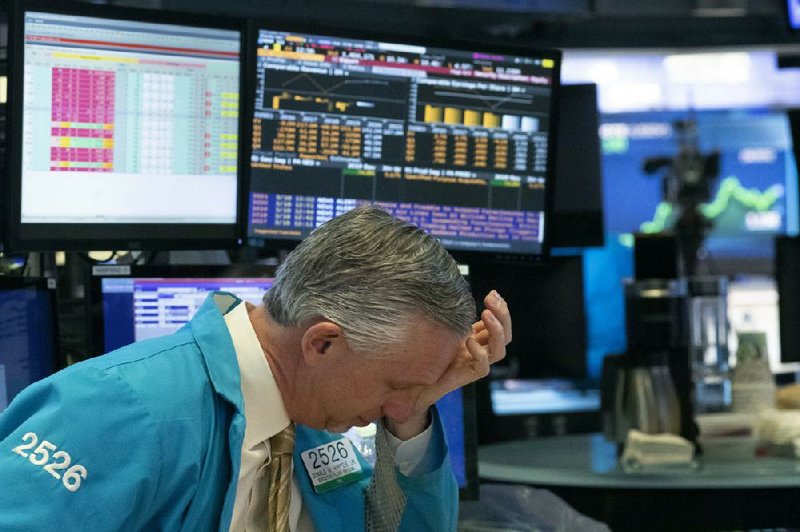 A trader pauses Wednesday at the New York Stock Exchange while trading was briefly halted during a renewed frantic sell-off of stocks.
(AP/Mark Lennihan)