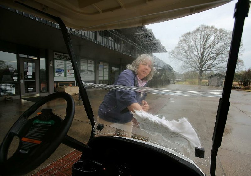 Dawn Darter, the golf professional at The Greens at North Hills in  Sherwood, wipes down a golf cart at the course Thursday. While  Little Rock city courses are shut down, some others are taking  extra precautions amid concerns of the coronavirus outbreak.
(Arkansas Democrat-Gazette/Thomas Metthe)