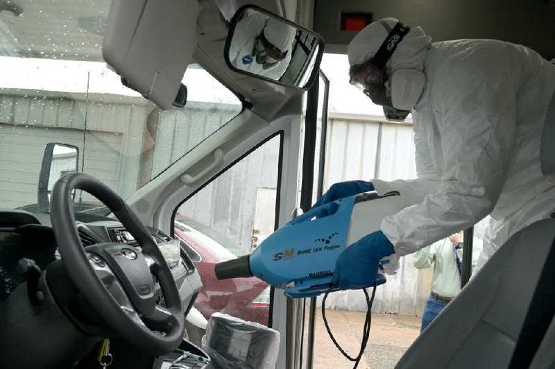 Bruce Phifer uses a fogger filled with hydrogen peroxide to disinfect an airport shuttle bus Thursday at Little Rock Coaches.
(Arkansas Democrat-Gazette/Stephen Swofford)