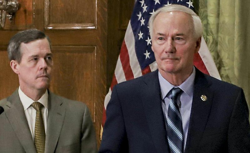 Dr. Cam Patterson, chancellor of the University of Arkansas for Medical Sciences, stands back as Gov. Asa Hutchinson exits a news conference on the coronavirus Friday at the state Capitol. More photos at arkansasonline.com/321govcovid/.
(Arkansas Democrat-Gazette/John Sykes Jr.)