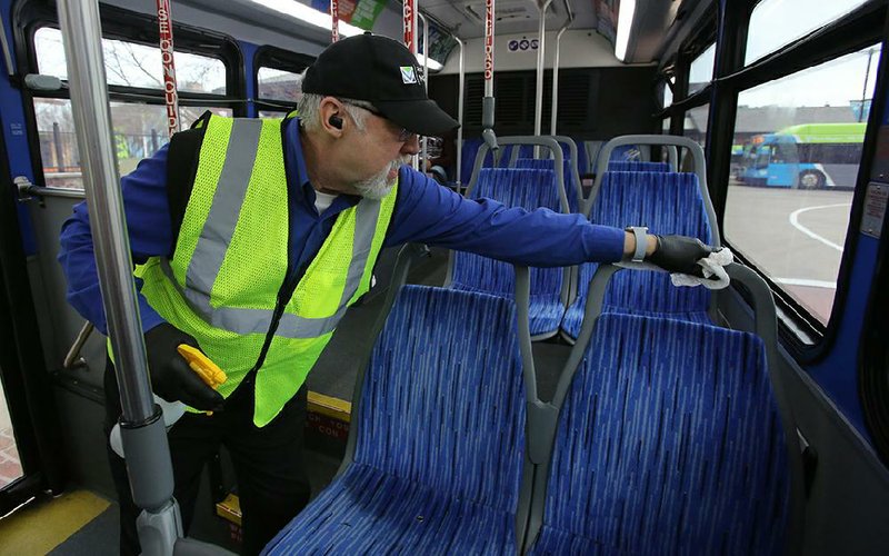 Gerald Wright sanitizes a Rock Region METRO bus at the River Cities Travel Center on Friday, March 20, 2020, in Little Rock. Wright, says his normal job is trolley driver, but since trolley's are not running he say he's been "repurposed" to help out in other areas. 
(Arkansas Democrat-Gazette/Thomas Metthe)