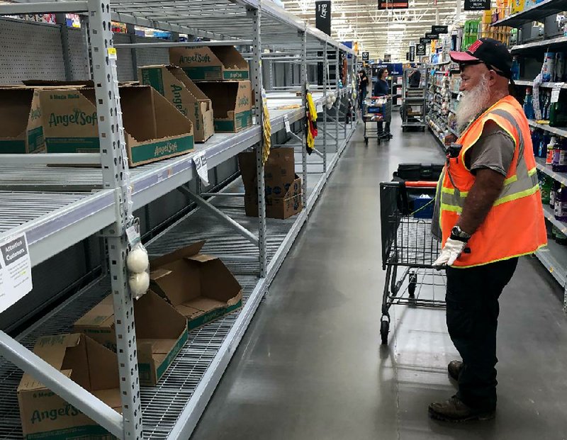 Bare toilet paper shelves greet a shopper Friday at a Phoenix Walmart Supercenter. Walmart said Friday that it is hiring 150,000 more workers, 3,000 in Arkansas, to help keep operations going during the pandemic.
(AP/Bob Christie)