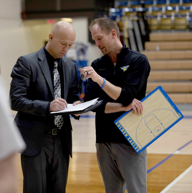 Nicholas Robinson/JBU Sports Information John Brown assistant men's coach Tim Kisner, left, and head coach Jason Beschta strategize during the Sooner Athletic Conference Tournament on March 7 in Plainview, Texas.