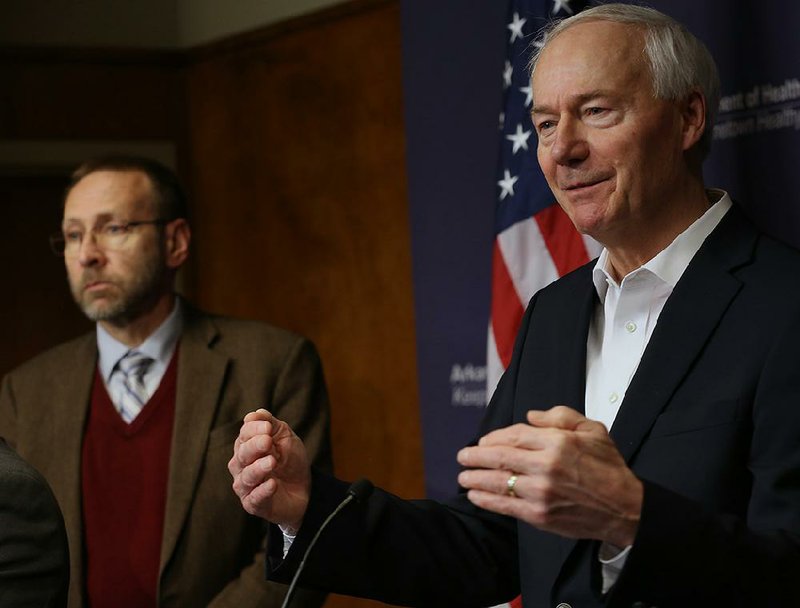 Gov. Asa Hutchinson said Saturday at the state Department of Health that the expected number of hospitalizations from the virus “strains our hospitals, our medical system and our economy and it endangers lives.” At left is Dr. Nate Smith, the Health Department director.
(Arkansas Democrat-Gazette/Thomas Metthe)