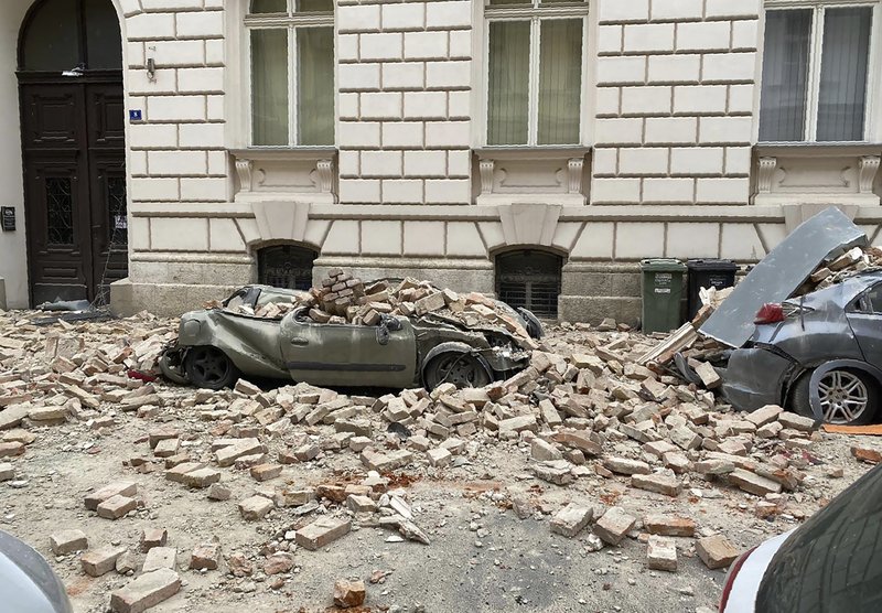 A car lies crushed by falling debris after an earthquake Sunday in Zagreb, Croatia. (AP/Darko Bandic) 
