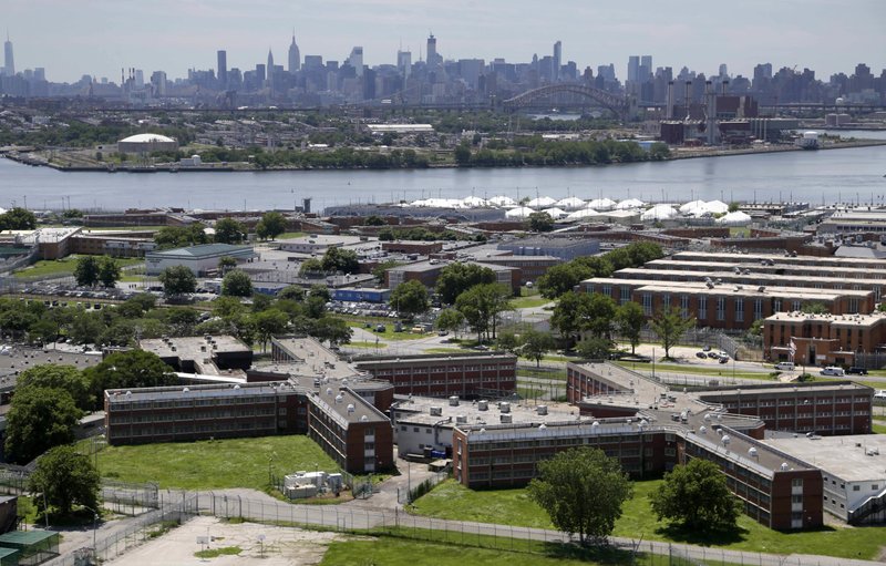 This 2014 file photo shows the Rikers Island jail complex in New York with the Manhattan skyline in the background. More than three dozen people have tested positive for coronavirus in New York City jails, including at the complex, the board that oversees the city’s jail system said Saturday. (AP/Seth Wenig) 