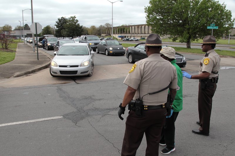 In this file photo Jefferson County Sheriff's Office deputies help direct traffic Monday morning at the Pine Bluff Convention Center. Hundreds of vehicles spread outward in all directions from the convention center Monday morning, some arriving as early as 6 a.m., in anticipation of food donations from Tyson Foods. (Arkansas Democrat-Gazette/Dale Ellis) 