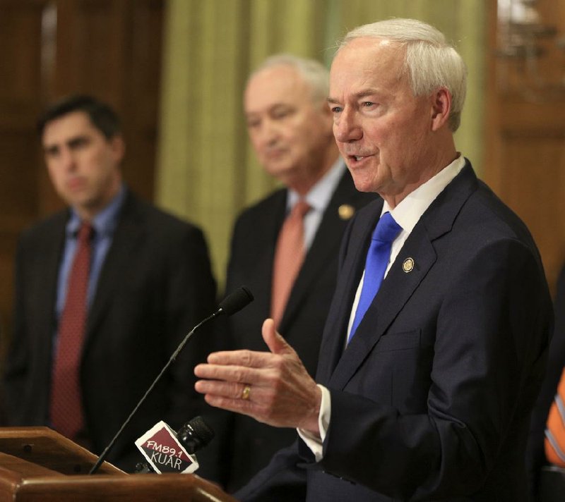 In this file photo Gov. Asa Hutchinson, right, speaks along with Larry Walther, middle, Secretary of the Department of Finance and Administration and Jake Bleed, state budget director, in Little Rock during a daily press conference about the corona virus in Arkansas. 
 (Arkansas Democrat-Gazette/Staton Breidenthal)  

