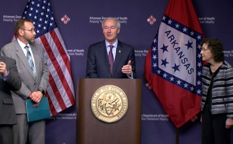 Gov. Asa Hutchinson, center, speaks during a news conference on Tuesday where he announced the first deaths from covid-19 in the state of Arkansas.