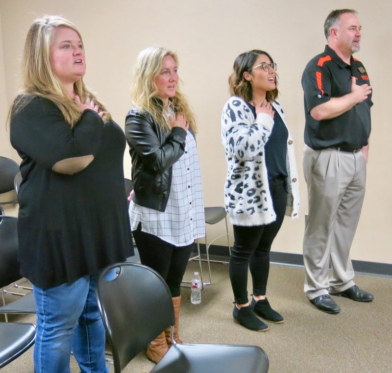 Westside Eagle Observer/SUSAN HOLLAND Glenn Duffy Elementary School teachers and their principal, Zane Vanderpool, lead the pledge of allegiance to open the March meeting of the Gravette School Board. Pictured are Jennifer Davis (left), Faith Hendricks, Kristy Sanders and Vanderpool. The three teachers were recognized for achieving National Board Certification, the most respected professional certification in K-12 education.