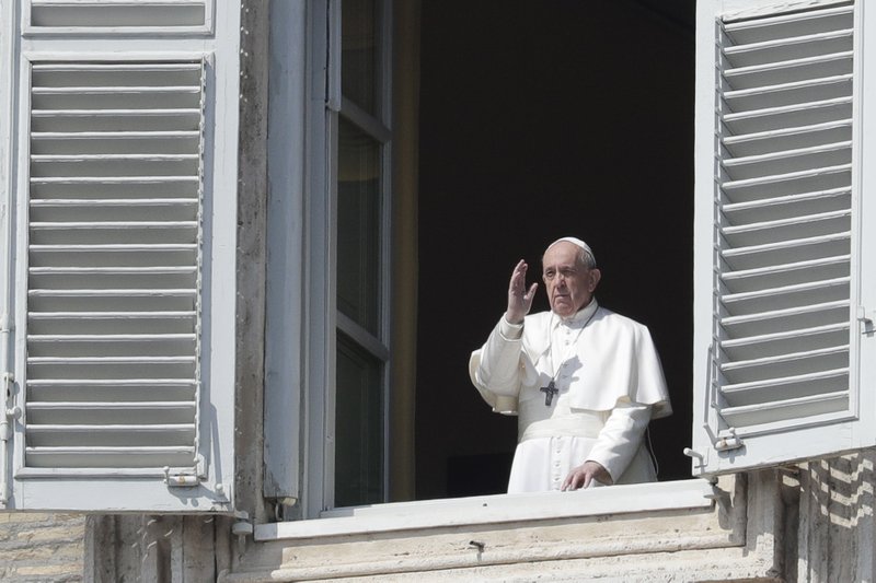 Pope Francis delivers his blessing from the window of his private library overlooking St. Peter's Square, at the Vatican, Sunday, March 22, 2020. During his weekly Sunday blessing, held due to virus concerns in his private library in the Apostolic Palace, he urged all Christians to join in reciting the "Our Father" prayer next Wednesday at noon. And he said that he would lead a global blessing to an empty St. Peter's Square on Friday. For most people, the new coronavirus causes only mild or moderate symptoms. For some it can cause more severe illness, especially in older adults and people with existing health problems. (AP Photo/Andrew Medichini)