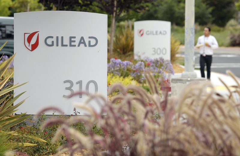 In this July 9, 2015, file photo, a man walks outside the headquarters of Gilead Sciences in Foster City, Calif. Gilead Sciences said Wednesday, March 25, 2020 it will give up the specialty status it received days earlier for its COVID-19 drug amid public outrage that the company was seeking to boost the profits of its treatment. (AP Photo/Eric Risberg, File) story.lead_photo.caption