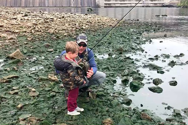 Jeremiah Gage talks with his 3-year-old son Wyatt during a recent fishing trip on the White River.