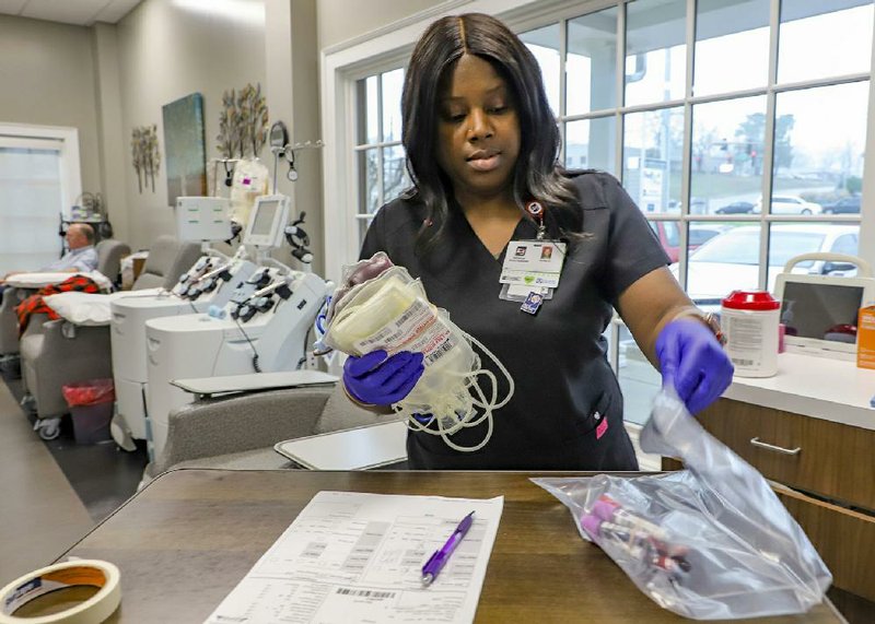 Ashley Austin, a phlebotomist at the Arkansas Blood Institute in Little Rock, arranges her station after taking blood Tuesday morning,
(Arkansas Democrat-Gazette/John Sykes Jr.)
