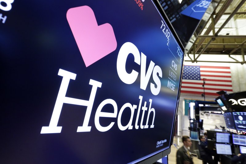 FILE - In this Dec. 4, 2017 file photo, the CVS Health logo appears above a trading post on the floor of the New York Stock Exchange. CVS Health's Aetna is waiving patient payments for hospital stays tied to the coronavirus.  (AP Photo/Richard Drew, File)