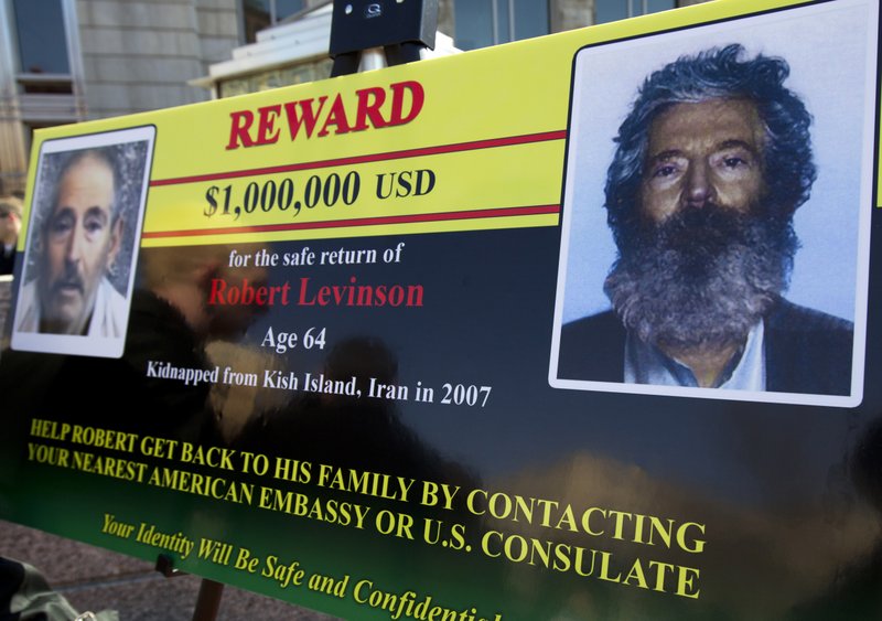 FILE - In this March 6, 2012 file photo, an FBI poster showing a composite image of former FBI agent Robert Levinson, right, of how he would look like now, left, taken from the video, released by his captors in Washington during a news conference. The family of retired FBI agent Levinson said Wednesday, March 25, 2020, that U.S. government officials have concluded that he has died while in the custody of Iran. (AP Photo/Manuel Balce Ceneta, File)