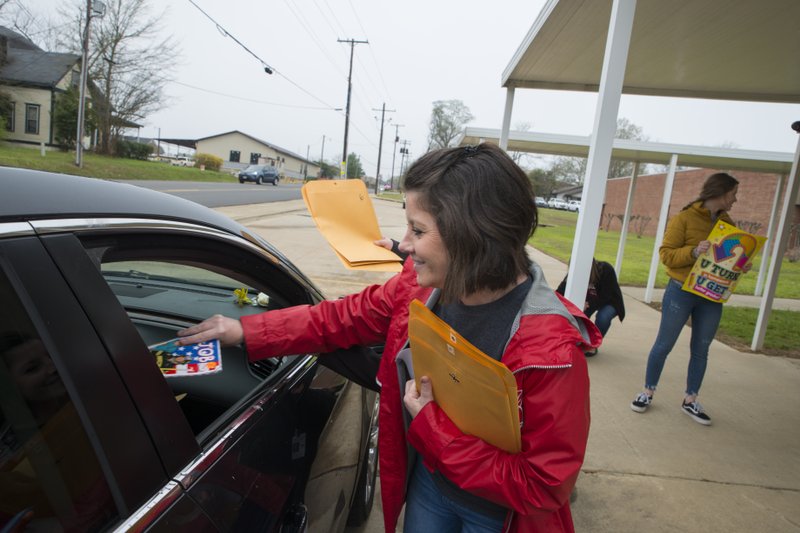 A March 16, 2020, photo shows fifth grade teacher Leslie Boyd handing out Alternative Method of Instruction (AMI) packets at Central Elementary School in Magnolia. The packets are now set to be distributed through the mail to all K-12 Magnolia students. They are also available online as all Arkansas schools remain out of in-person session until April 17. 