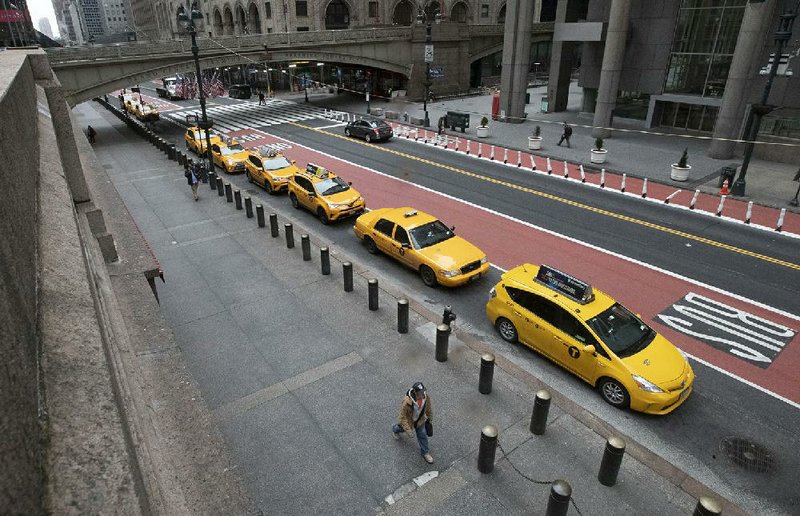 New York City taxis wait for fares Wednesday on an empty 42nd Street outside Grand Central Terminal. Big cities are taking drastic action to slow the coronavirus spread, and now small towns and rural areas are beginning to sound the alarm. More photos at arkansasonline.com/326outbreak/.
(AP/Mary Altaffer)