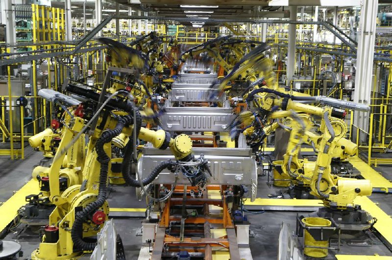 Robots weld the beds of Ford F-150 trucks on the assembly line at a plant in Dearborn, Mich., in this file photo. Ford is among automakers working to reopen their North American assembly plants in April.
(AP/Carlos Osorio)