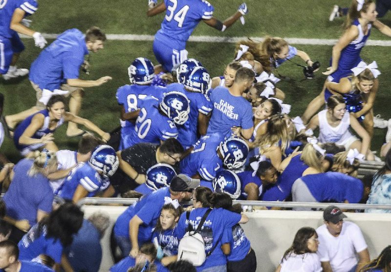Bryant High School football players, cheerleaders, fans and officials scramble for cover after hearing what was thought to be gun shots from the stands during the Salt Bowl game against Benton at War Memorial Stadium in Little Rock on Aug. 25, 2018. An investigation later determined that a stun gun was activated during a fight in the stands.
(Democrat-Gazette file photo)