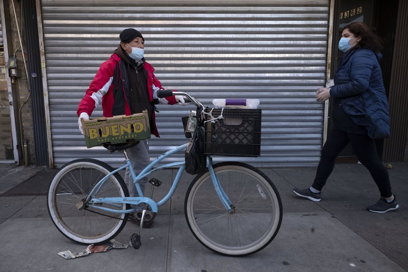 A man balances boxes of food that he picked up from Masbia Soup Kitchen, Thursday, March 26, 2020 during the coronavirus pandemic in the Brooklyn borough of New York. (AP Photo/Mark Lennihan)