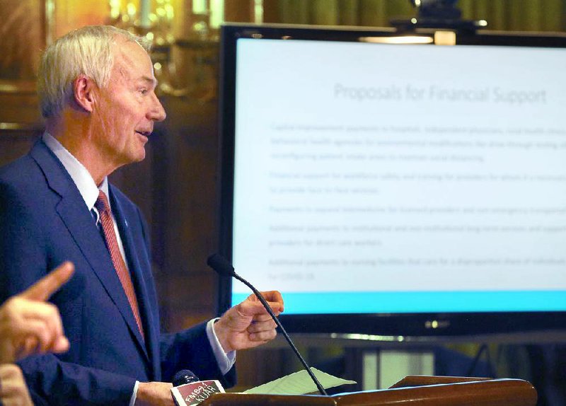 “Health care today cannot be delivered just like it was two weeks ago,” Gov. Asa Hutchinson said Thursday at the state Capitol as he discussed new funding proposals related to the coronavirus fight. More photos at arkansasonline.com/327covid/.
(Arkansas Democrat-Gazette/Thomas Metthe)