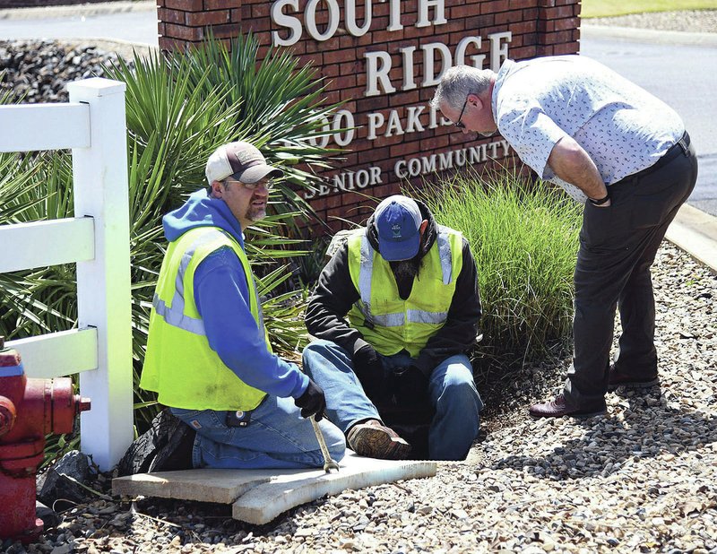 Hot Springs Utility employees Josh Tillery (left) and Roger Kalas, show their work Wednesdsay on a water main to Monty Ledbetter, director of utilities for Hot Springs, in the 600 block of Pakis Road in Hot Springs. (The Sentinel-Record/ Grace Brown)