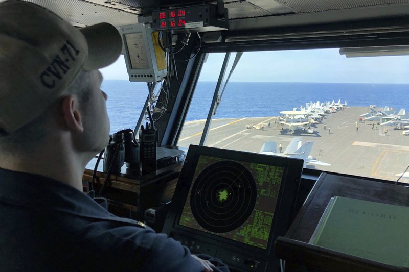 FILE - In this April 10, 2018, file photo, a U.S. Navy crewman monitors on the deck of the U.S. aircraft carrier Theodore Roosevelt in international waters off South China Sea. The USS Theodore Roosevelt made the second-ever visit by a U.S. aircraft carrier strike group to Vietnam to mark 25 years of diplomatic relations and growing security ties between the former Cold War antagonists amid China's aggressive moves in the South China Sea. - AP Photo/Jim Gomez, File