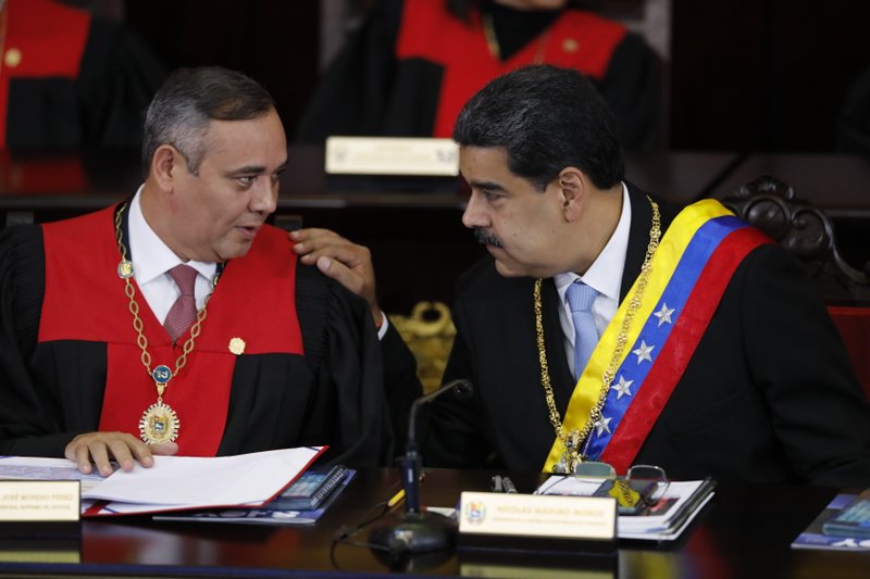 FILE - In this Jan. 31, 2020 file photo, Venezuelan President Nicolas Maduro, right, speaks with Supreme Court President Maikel Moreno at the Supreme Court in Caracas, Venezuela. Maduro is at the court to give his annual presidential address. On Thursday, March 26, 2020, the U.S. Justice Department made public it has charged in several indictments against Maduro and his inner circle, including Moreno, that the leader has effectively converted Venezuela into a criminal enterprise at the service of drug traffickers and terrorist groups as he and his allies stole billions from the South American country. (AP Photo/Ariana Cubillos, File)