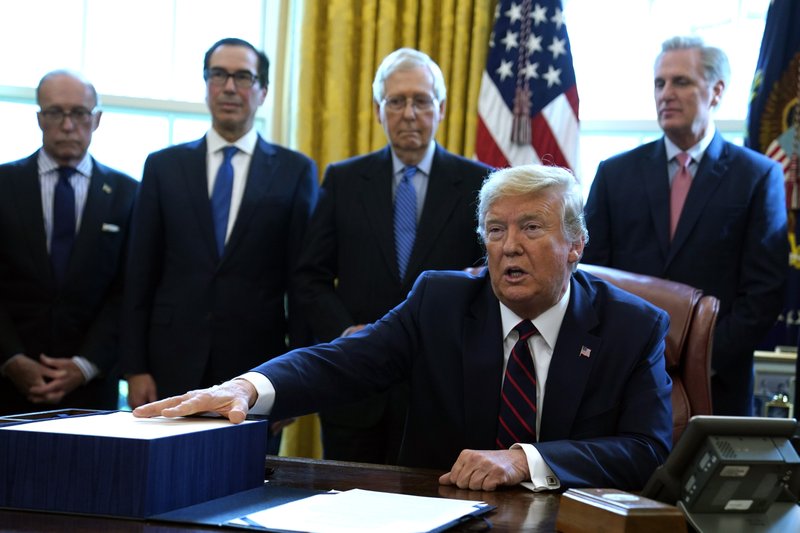 President Donald Trump speaks before he signs the coronavirus stimulus relief package in the Oval Office at the White House on Friday in Washington. Listening are from left, Larry Kudlow, White House chief economic adviser, Treasury Secretary Steven Mnuchin, Senate Majority Leader Mitch McConnell, R-Ky., and House Minority Leader Kevin McCarty of Calif. - AP Photo/Evan Vucci