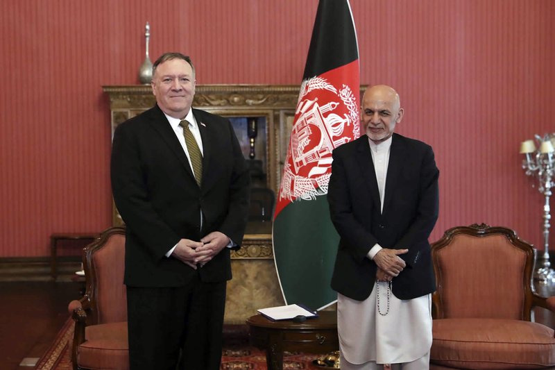 U.S. Secretary of State Mike Pompeo, left, stands with Afghan President Ashraf Ghani, at the Presidential Palace in Kabul, Afghanistan, Monday, March 23, 2020. Pompeo was in Kabul on an urgent visit Monday to try to move forward a U.S. peace deal signed last month with the Taliban, a trip that comes despite the coronavirus pandemic, at a time when world leaders and statesmen are curtailing official travel. (Afghan Presidential Palace via AP)