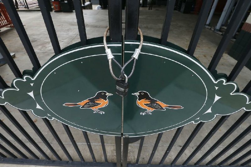 Locked gates are shown Thursday at Oriole Park at Camden Yards, home of the Baltimore Orioles, in Baltimore on what was to be Opening Day. Major League Baseball owners ratifi ed a 17-page agreement with the union on Friday, with players willing to extend the season as long as needed to cover as close to a full schedule as possible.
(AP/Steve Helber)