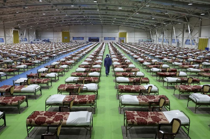 An Iranian soldier walks past rows of beds Thursday at a temporary hospital set up at an exhibition center in Tehran to treat coronavirus patients.
(AP/Ebrahim Noroozi)