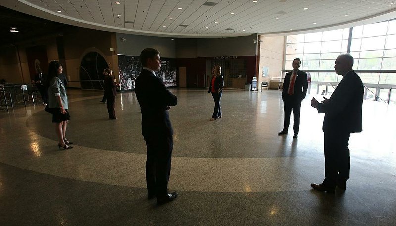 House members chat at a distance before Friday’s session. In the special legislative session, the House is holding its meetings at the Jack Stephens Center, the basketball arena at the University of Arkansas at Little Rock, where they can spread out. More photos at arkansasonline.com/328covidbills/.
(Arkansas Democrat-Gazette/Thomas Metthe)