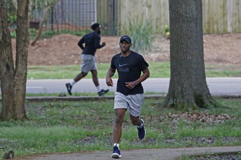 Runners take advantage of the 1-mile Parham Bridges walking track Monday in Jackson, Miss. Runners across the country are still hitting the pavement and the trails, staying fit and working off some stress amid the coronavirus pandemic. It also provides a social outlet in a time when the sports world has mostly been shut down and officials are encouraging social distancing. - Photo by Rogelio V. Solis of The Associated Press