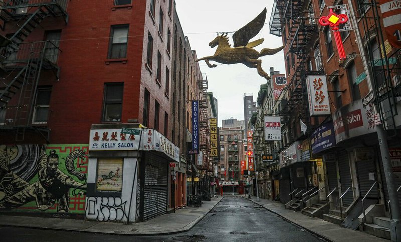 A street in New York's Chinatown is empty, the result of citywide restrictions calling for people to stay indoors and maintain social distancing in an effort to curb the spread of COVID-19, Saturday March 28, 2020, in New York. President Donald Trump says he is considering a quarantine affecting residents of the state and neighboring New Jersey and Connecticut amid the coronavirus outbreak, but New York Gov. Andrew Cuomo said that roping off states would amount to "a federal declaration of war." (AP Photo/Bebeto Matthews)