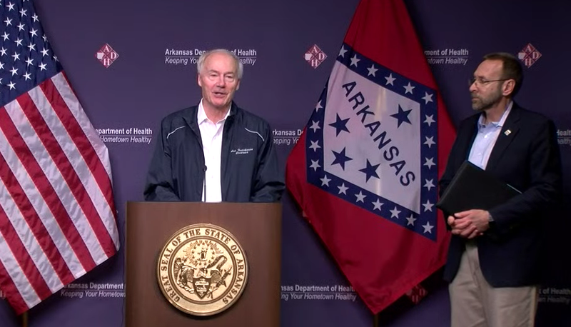 Arkansas Gov. Asa Hutchinson and state health officials speak to reporters Sunday in this screengrab of video provided by the governor’s office. 
