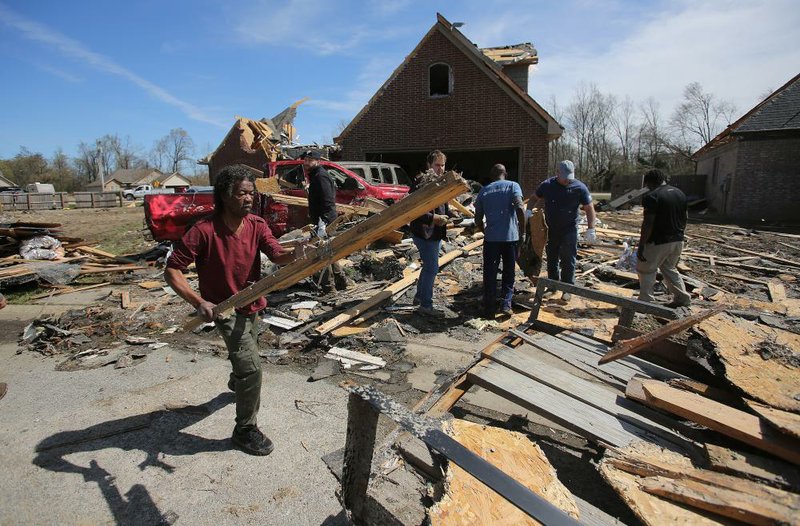 Johnny Washington (left) removes debris from his home on Sunday after it was destroyed by the tornado that hit Jonesboro on Saturday afternoon. More photos at arkansasonline.com/330tornado/. (Arkansas Democrat-Gazette/Thomas Metthe) 

