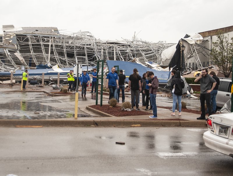 A group of people stand outside a damaged Best Buy after a tornado touched down Saturday at The Mall at Turtle Creek in Jonesboro. - Quentin Winstine/The Jonesboro Sun via AP