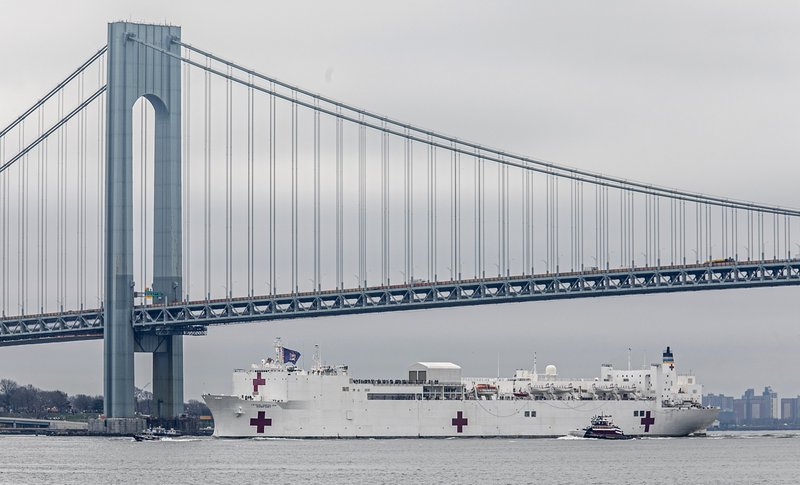 The Navy hospital ship USNS Comfort passes under the Verrazzano-Narrows Bridge on its way to docking in New York, Monday, March 30, 2020. The ship has 1,000 beds and 12 operating rooms that could be up and running within 24 hours of its arrival on Monday morning. It's expected to bolster a besieged health care system by treating non-coronavirus patients while hospitals treat people with COVID-19. (AP Photo/Bebeto Matthews