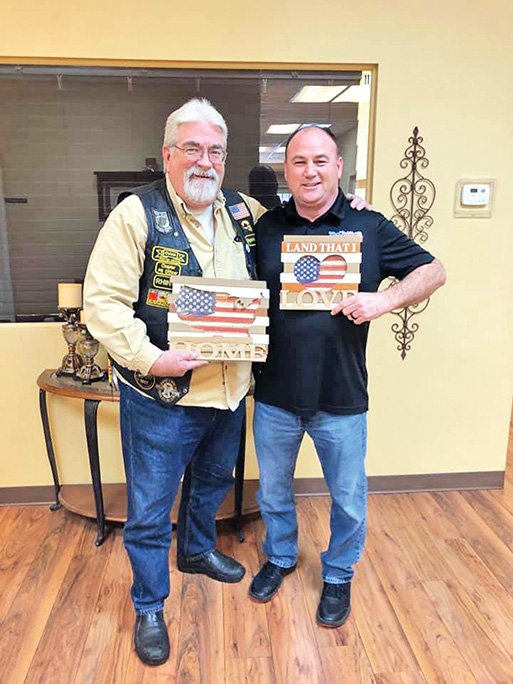 Bill Morton, left, accepts a gift from Paul Bunn, president of the Veterans Outreach Ministries. On Feb. 13, the Veterans Outreach Ministries recognized Morton for his hard work for and dedication to veterans, and the organization proclaimed Feb. 13 as Bill Morton Appreciation Day.
