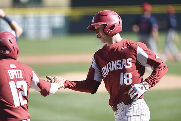 Arkansas outfielder Heston Kjerstad (18) is greeted at home plate by catcher Casey Opitz (12) during a game against South Alabama on Saturday, March 7, 2020, in Fayetteville.